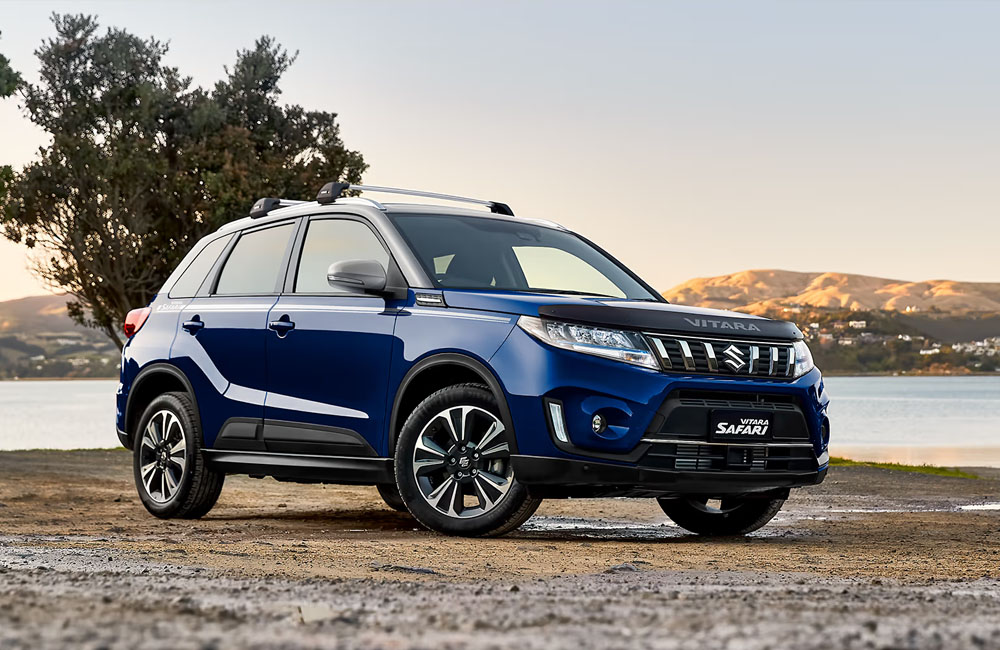 A blue Suzuki Vitara parked by a lake